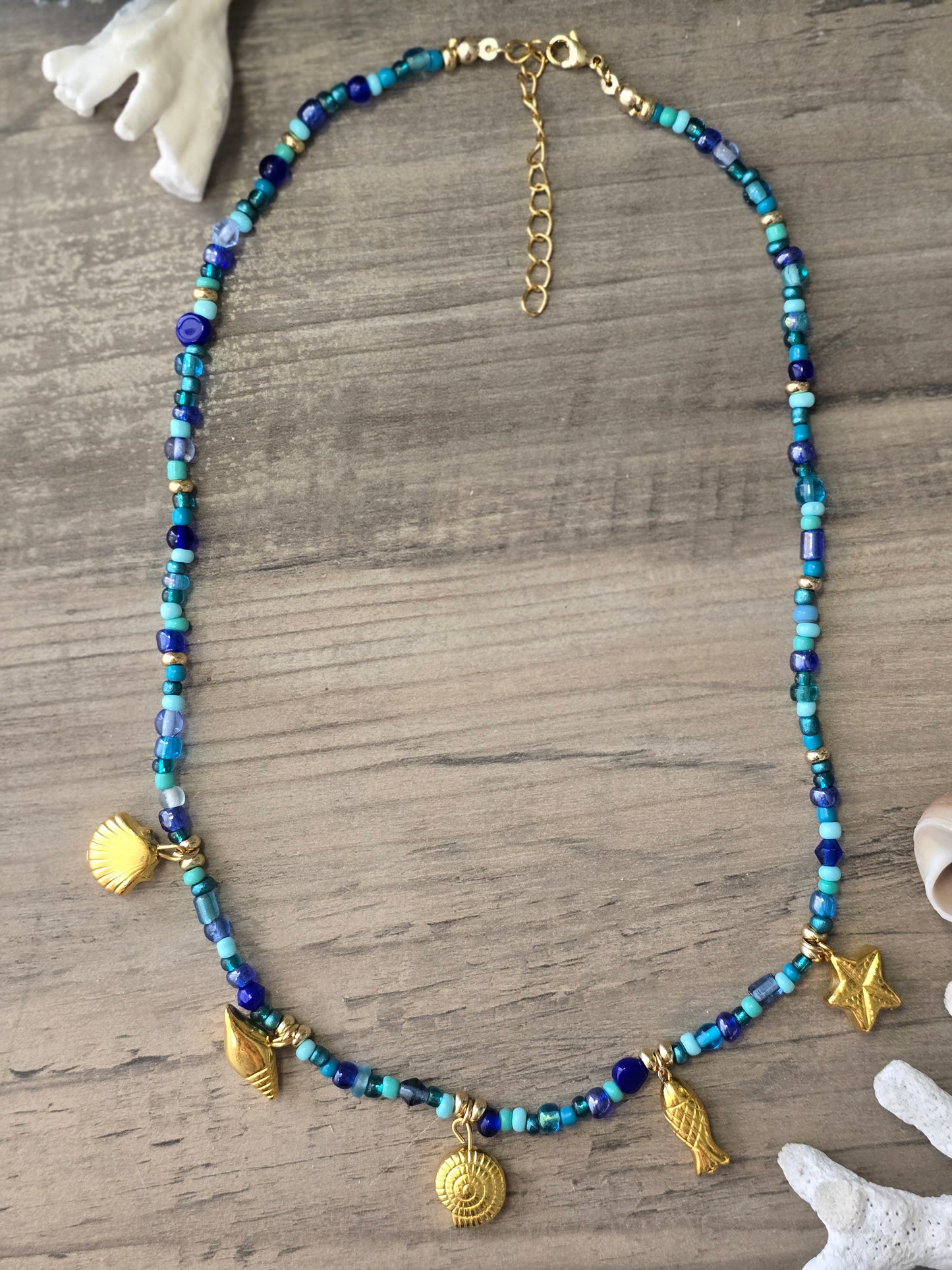 Collar azul de piedras en vidrio y colgantes dorados